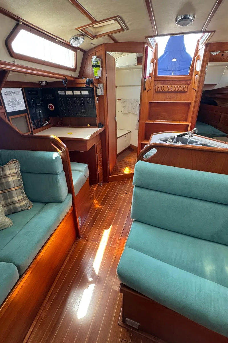 Slide: The Image of Interior of 1987 Sabre 42 sailboat with teal seating and wooden flooring. - 10