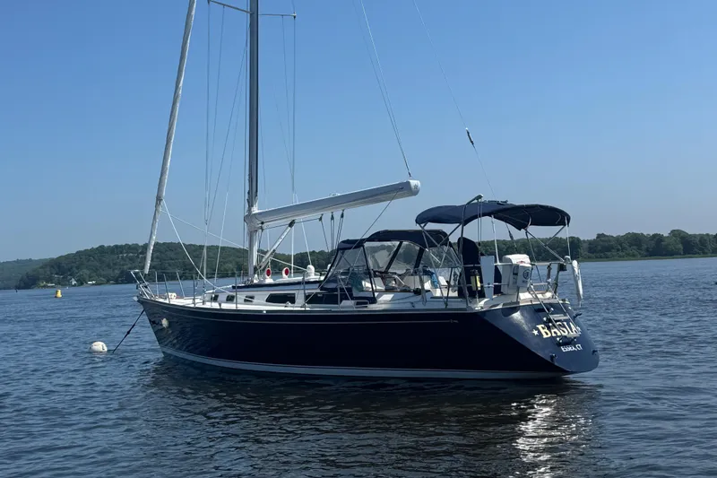 Slide: The Image of 1987 Sabre 42 sailboat anchored on calm water with clear blue sky. - 3