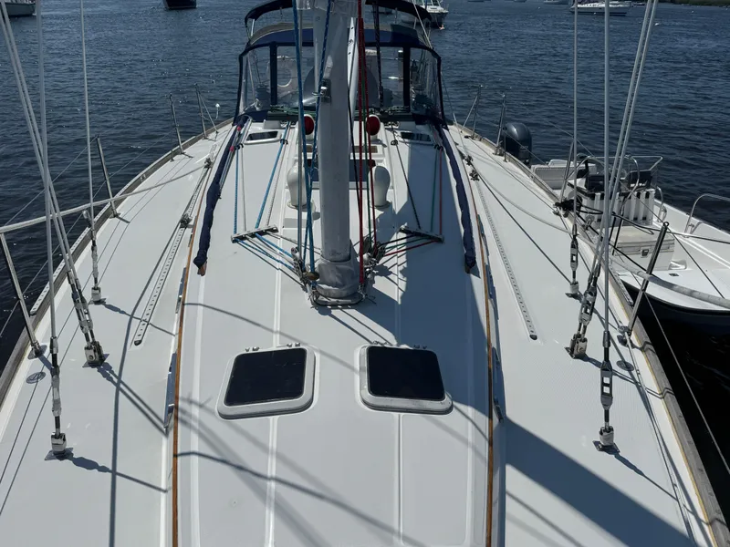 Slide: The Image of 1987 Sabre 42 sailboat deck with rigging, docked on calm water. - 7