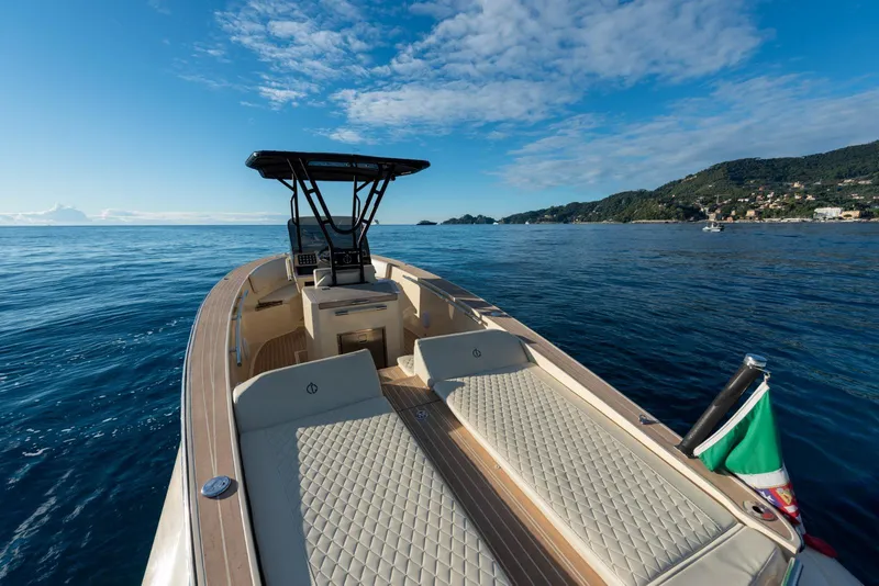 Slide: The Image of AlCustom Levanzo 25 boat cruising on calm sea, 2025 model, with scenic coastal backdrop. - 15