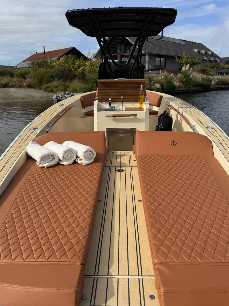 Slide: The Image of Luxurious AlCustom Levanzo 25 boat, 2025 model, with plush seating and scenic background. - 17