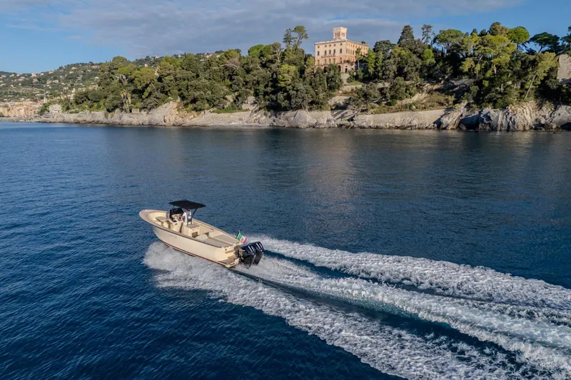 Slide: The Image of AlCustom Levanzo 25 boat cruising near scenic coastline, 2025 model. - 19