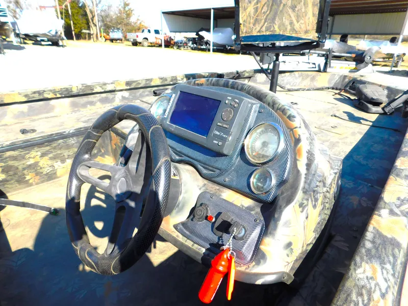 Slide: The Image of 2016 Triton 17 C TX boat dashboard with steering wheel and navigation system. - 1