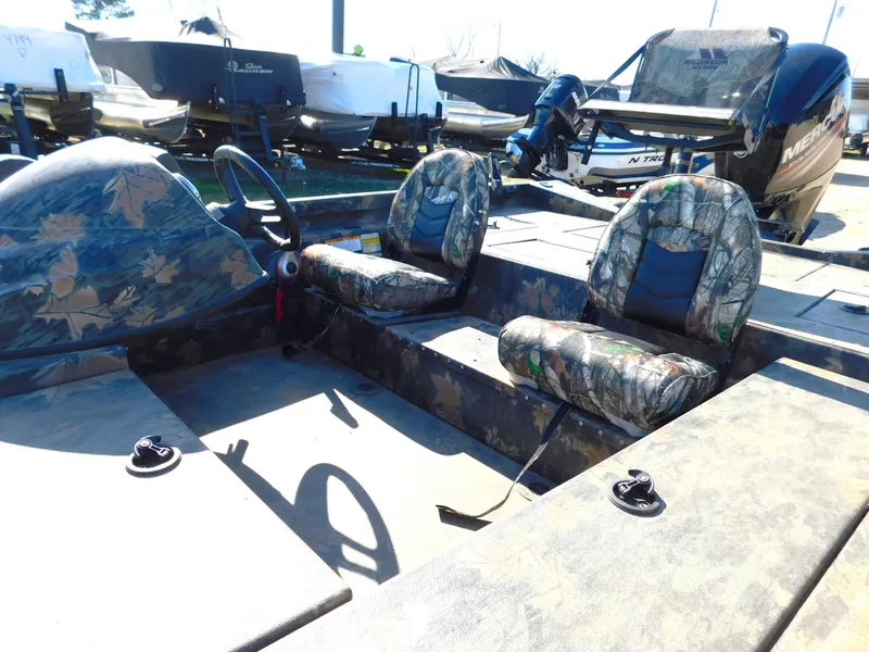 Slide: The Image of 2016 Triton 17 C TX boat interior with camouflage seats and steering wheel. - 2
