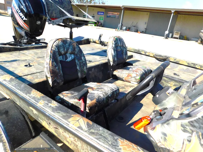 Slide: The Image of 2016 Triton 17 C TX boat interior with camouflage seats and Mercury outboard motor. - 3