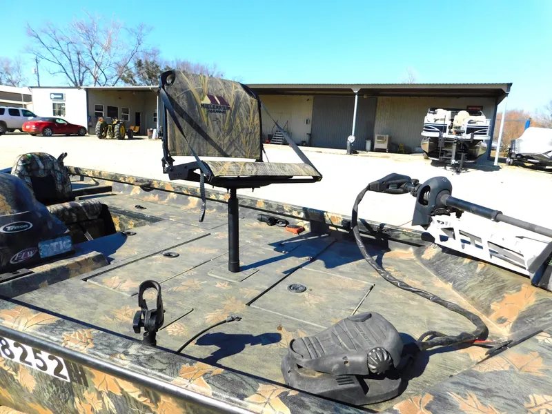 Slide: The Image of 2016 Triton 17 C TX boat with camouflage seating and trolling motor, parked outdoors. - 4