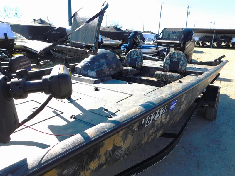Slide: The Image of 2016 Triton 17 C TX boat with camouflage seats, parked outdoors. - 6