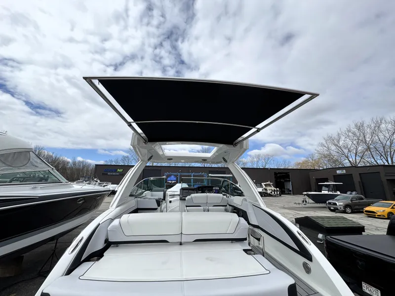 Slide: The Image of 2025 Formula 330 Crossover Bowrider I/O with sleek design and spacious seating under a cloudy sky. - 29