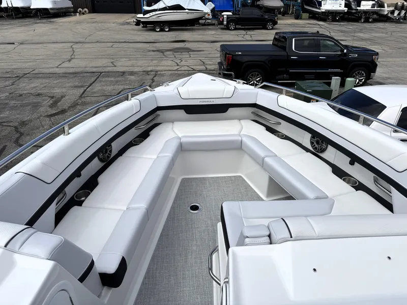 Slide: The Image of 2025 Formula 330 Crossover Bowrider I/O with spacious seating in a marina setting. - 32