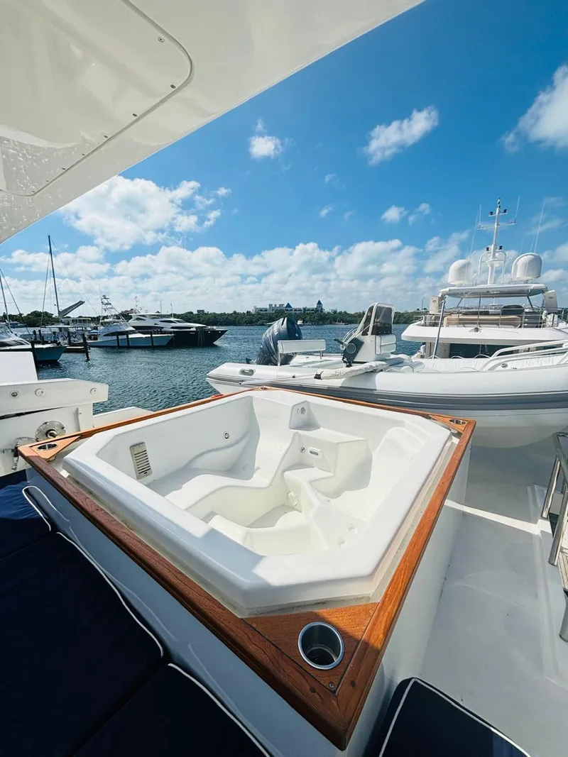 Slide: The Image of Luxurious Falcon Motoryacht 2000 with jacuzzi, docked under a clear blue sky. - 11