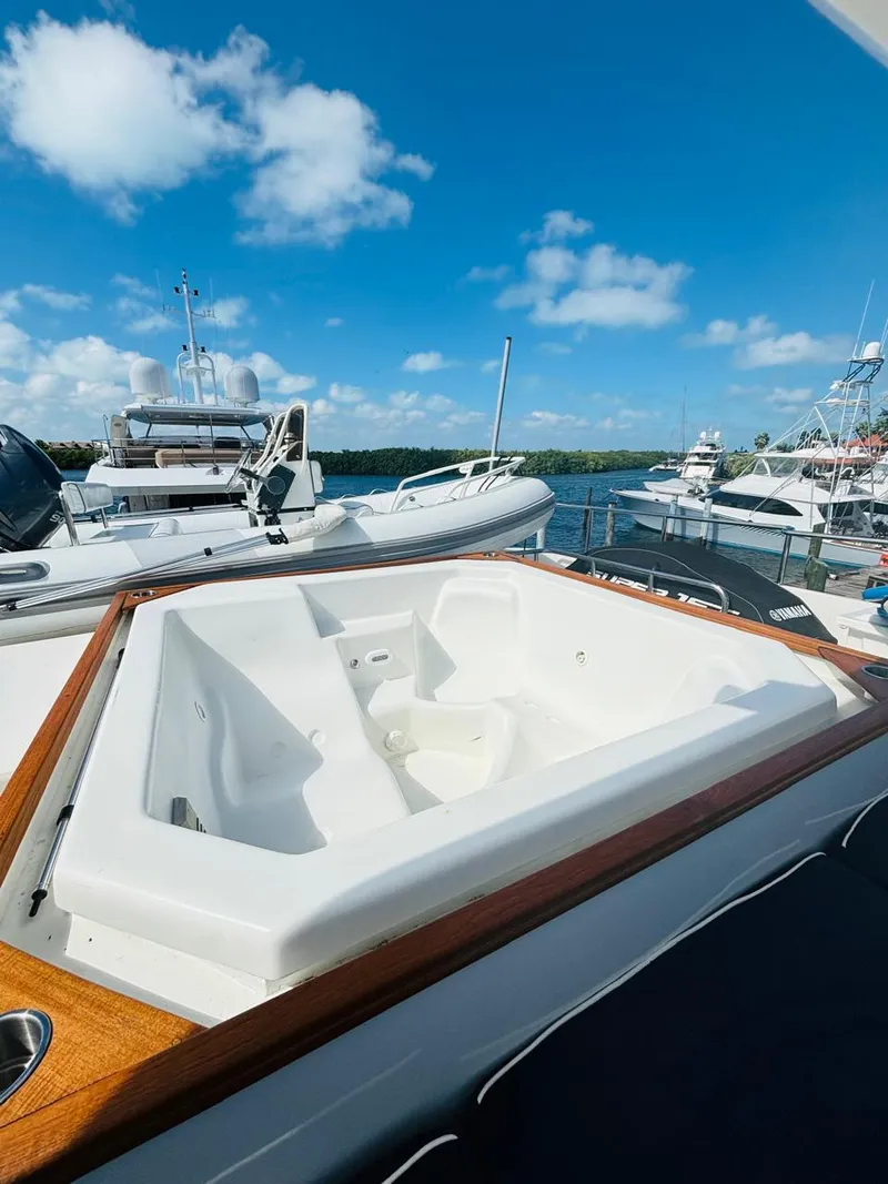 Slide: The Image of Luxurious Falcon Motoryacht 2000 with jacuzzi, docked under a clear blue sky. - 12