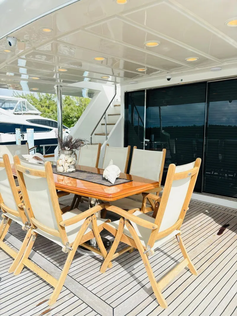Slide: The Image of Outdoor dining area on 2000 Falcon Motoryacht with wooden table and chairs. - 2