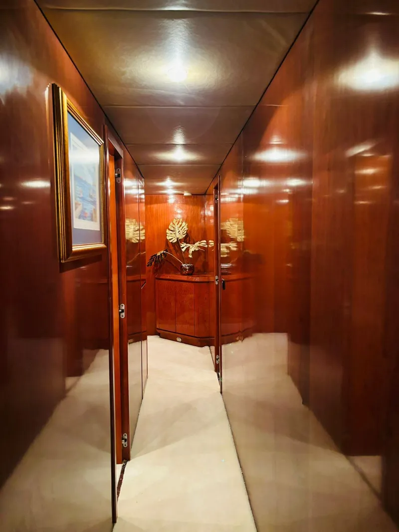 Slide: The Image of Luxurious wooden hallway inside 2000 Falcon Motoryacht, featuring elegant decor and artwork. - 37