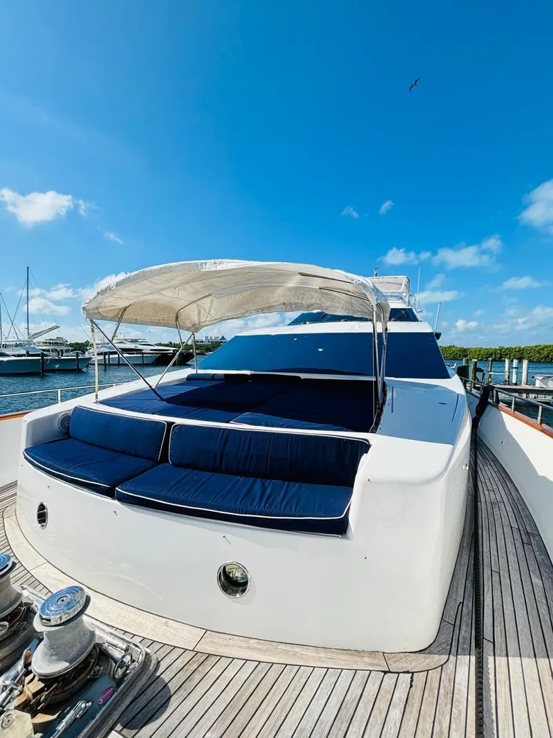 Slide: The Image of 2000 Falcon Motoryacht with sun deck, blue cushions, and canopy under clear blue sky. - 4