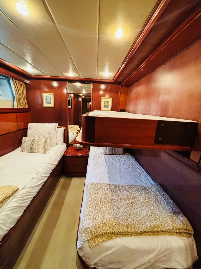 Slide: The Image of Luxurious Falcon Motoryacht 2000 cabin with twin beds and elegant wood paneling. - 44