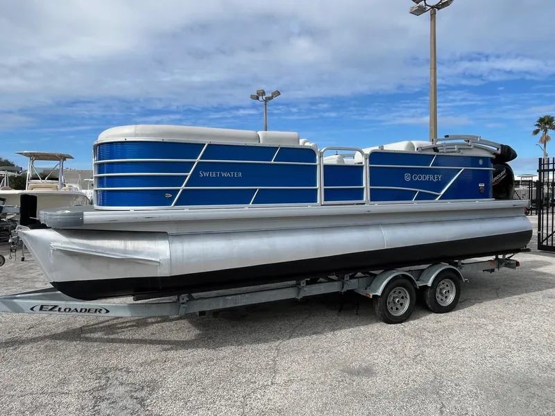 Slide: The Image of 2022 Godfrey Sweetwater 2286 C pontoon boat on trailer, blue and silver design. - 3