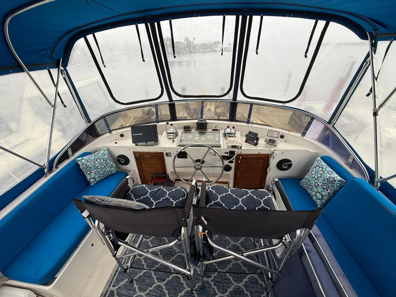 Slide: The Image of Interior view of 1986 Jefferson Sundeck boat with blue seating and steering controls. - 10
