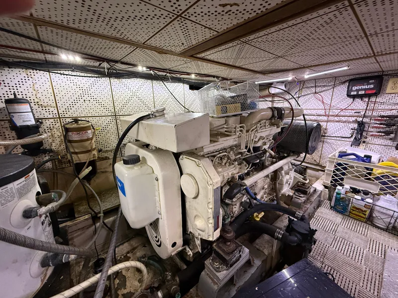 Slide: The Image of Engine room of a 1986 Jefferson Sundeck yacht, showcasing machinery and equipment. - 16
