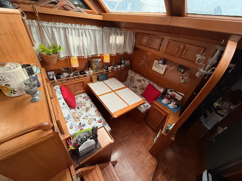 Slide: The Image of Cozy interior of a 1986 Jefferson Sundeck boat with wooden furnishings and floral decor. - 4