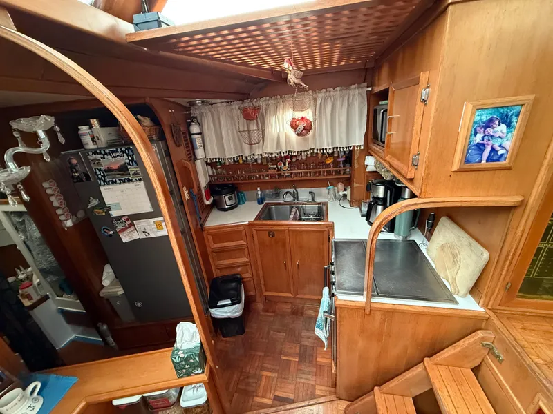 Slide: The Image of 1986 Jefferson Sundeck yacht kitchen with wooden cabinetry, stainless steel sink, and cozy decor. - 5