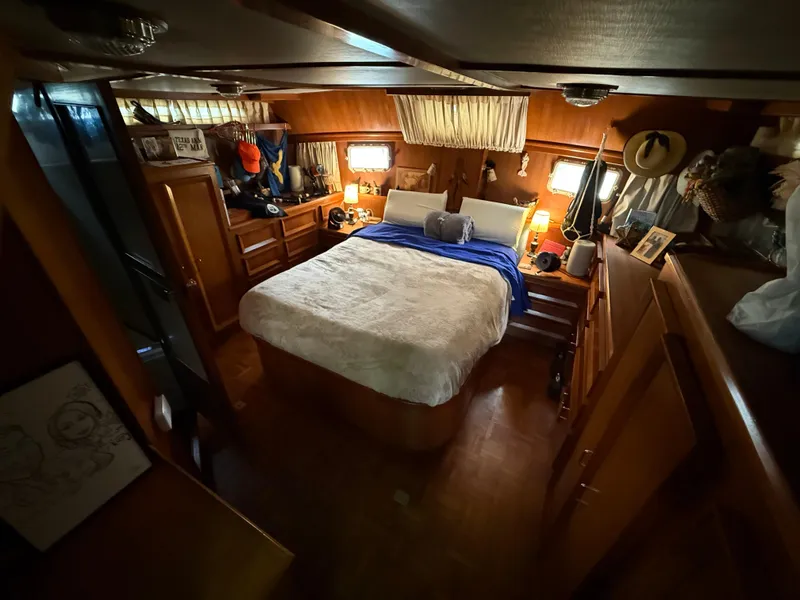 Slide: The Image of Cozy bedroom interior of 1986 Jefferson Sundeck yacht with wooden furnishings and ambient lighting. - 7
