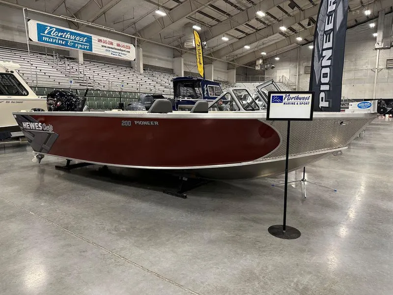 The Image of 2025 Hewescraft 200 Pioneer boat in showroom with mounted Yamaha engine. - 0