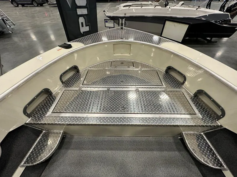 Slide: The Image of 2025 Hewescraft 200 Pioneer boat interior with diamond plate flooring. - 2