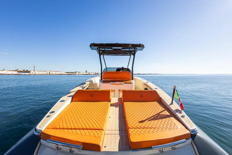 Slide: The Image of 2025 AlCustom LIPARI 31 boat with orange seating, cruising on calm blue waters. - 18
