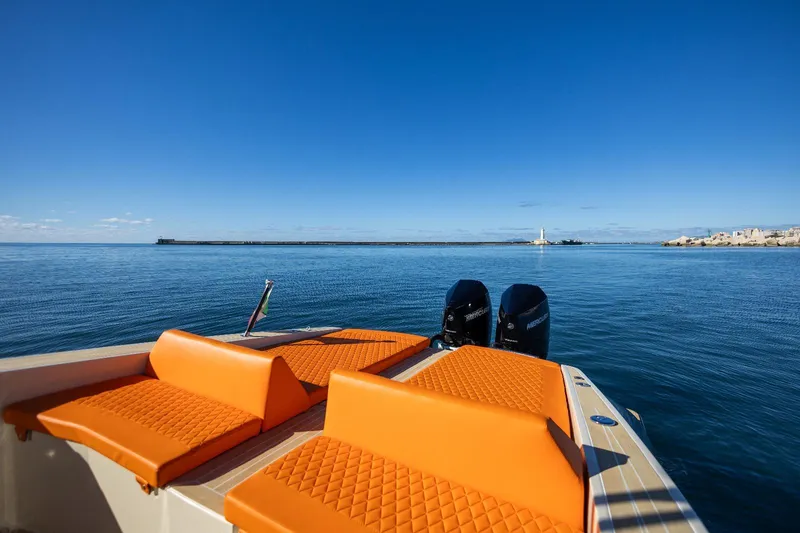 Slide: The Image of 2025 AlCustom LIPARI 31 boat with orange seating, dual engines, on calm blue water. - 19