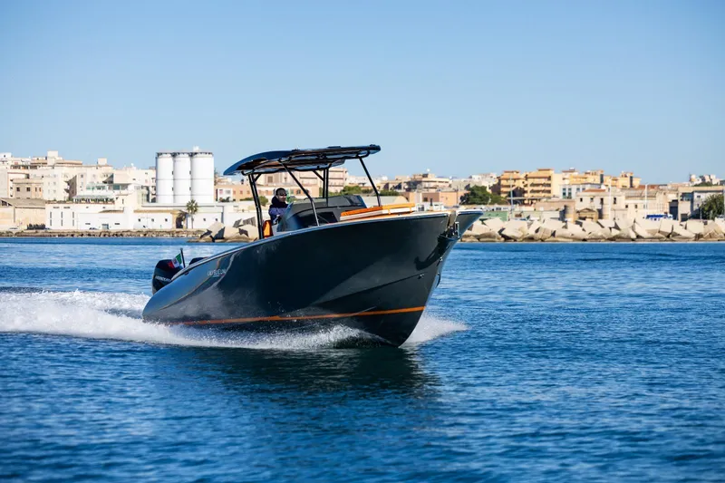 Slide: The Image of 2025 AlCustom LIPARI 31 boat cruising on blue water near urban shoreline. - 3