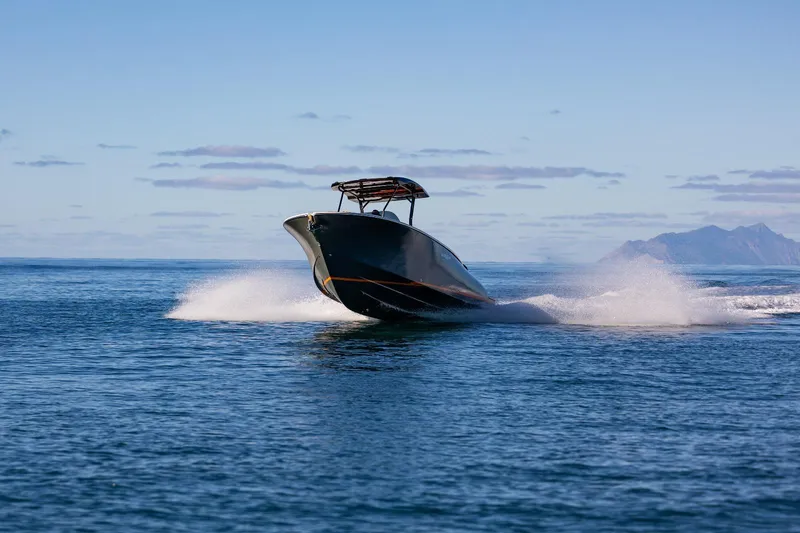 Slide: The Image of 2025 AlCustom LIPARI 31 speedboat cruising on open water with distant mountains. - 7
