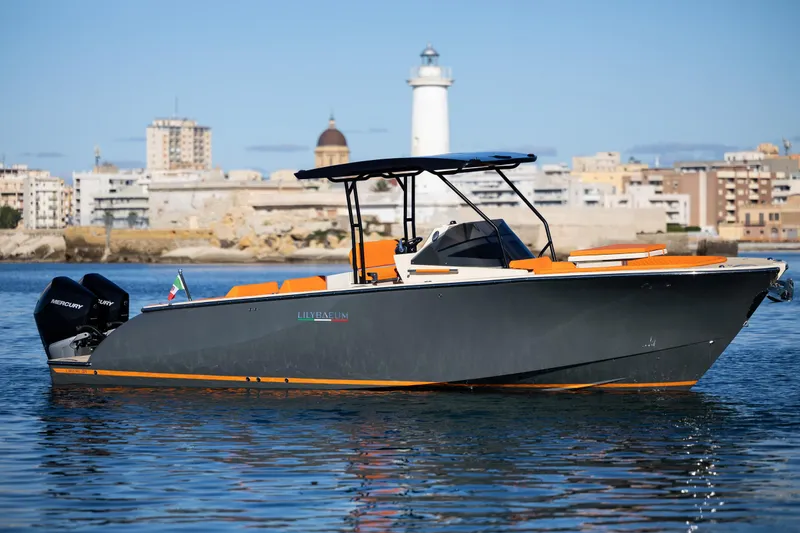 Slide: The Image of 2025 AlCustom LIPARI 31 boat on water, cityscape and lighthouse in background. - 0