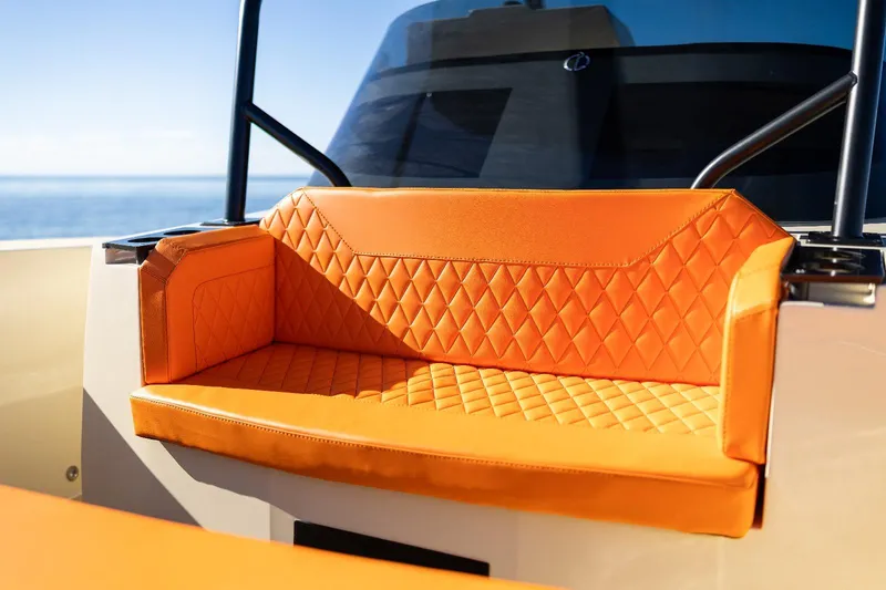 Slide: The Image of Orange quilted seat on 2025 AlCustom LIPARI 31 boat, with ocean view in background. - 11