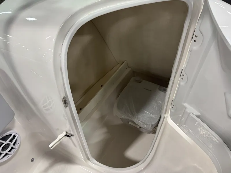 Slide: The Image of 2025 Robalo R207 Dual Console boat storage compartment with portable toilet. - 12