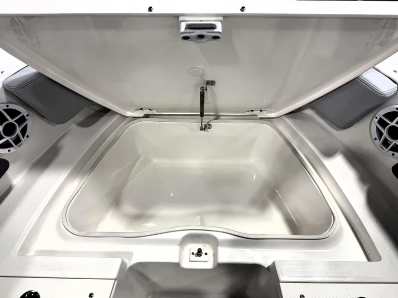 Slide: The Image of 2025 Robalo R207 Dual Console storage compartment, open lid, spacious interior, marine speakers visible. - 17