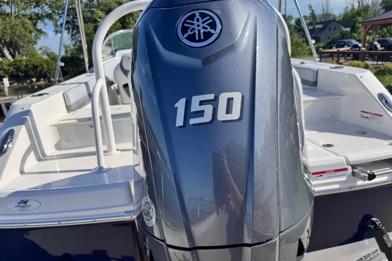 Slide: The Image of 2025 Robalo R207 Dual Console with Yamaha 150 outboard engine, docked outdoors. - 5