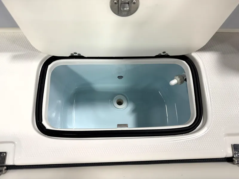 Slide: The Image of 2025 Robalo R207 Dual Console livewell with open lid, showcasing interior design. - 8