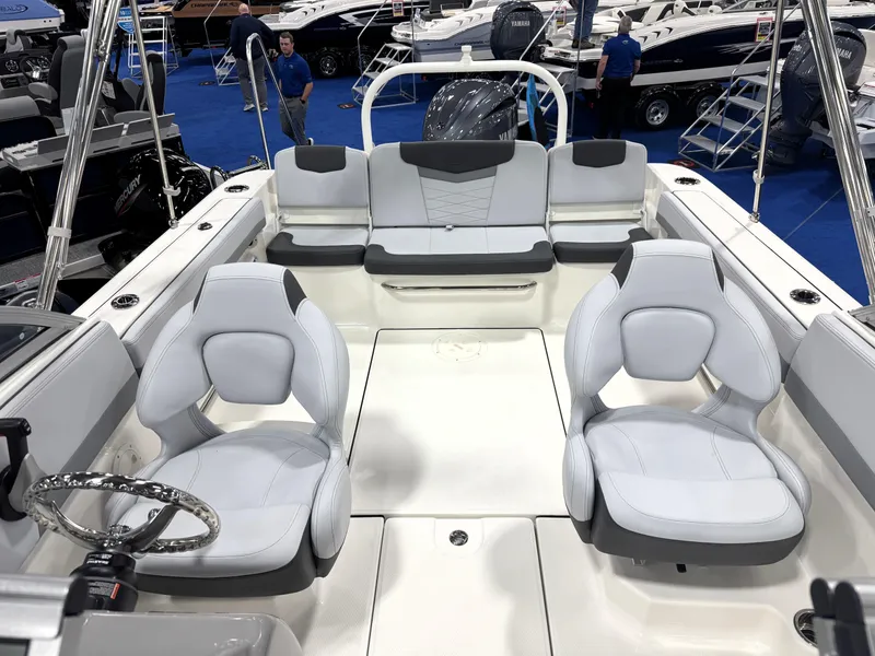 Slide: The Image of 2025 Robalo R207 Dual Console boat interior with white seating at a boat show. - 10