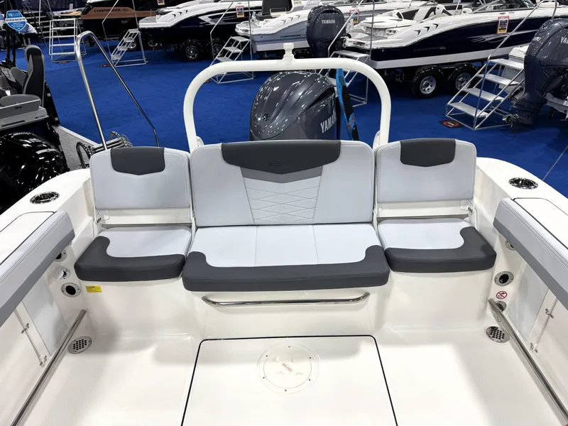 Slide: The Image of 2025 Robalo R207 Dual Console boat interior with cushioned seating at a boat show. - 22