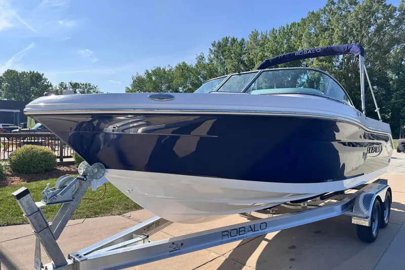 Slide: The Image of 2025 Robalo R207 Dual Console boat on trailer, parked outdoors. - 3