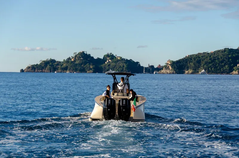 Slide: The Image of AlCustom Levanzo 25 boat cruising on open water, scenic island backdrop, 2025 model. - 4