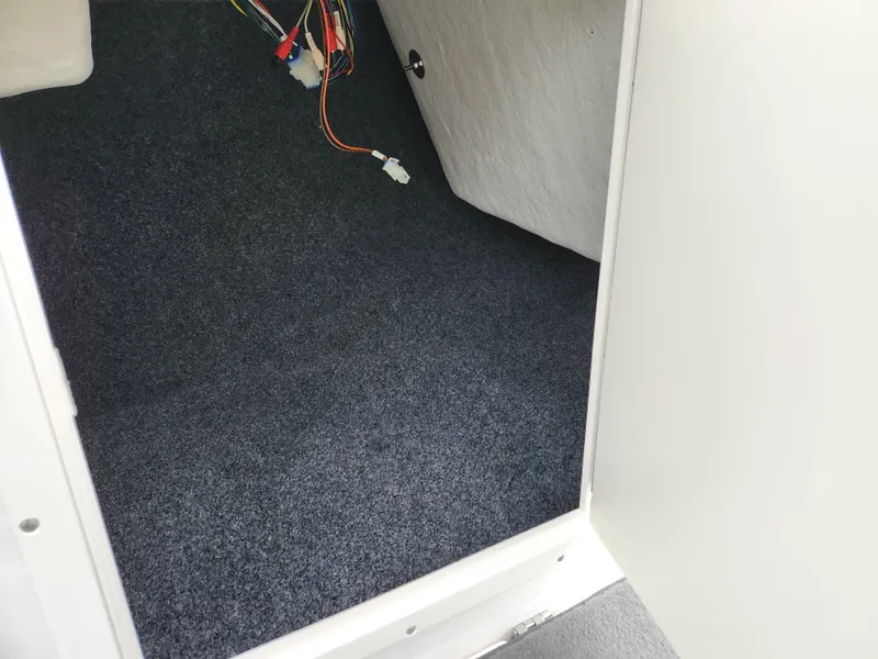 Slide: The Image of Interior view of a 2014 Yamaha Boats AR190, showing carpeted flooring and exposed wiring. - 13