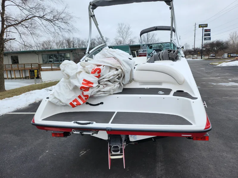 Slide: The Image of 2014 Yamaha Boats AR190 on pavement, rear view with cover, overcast sky. - 2