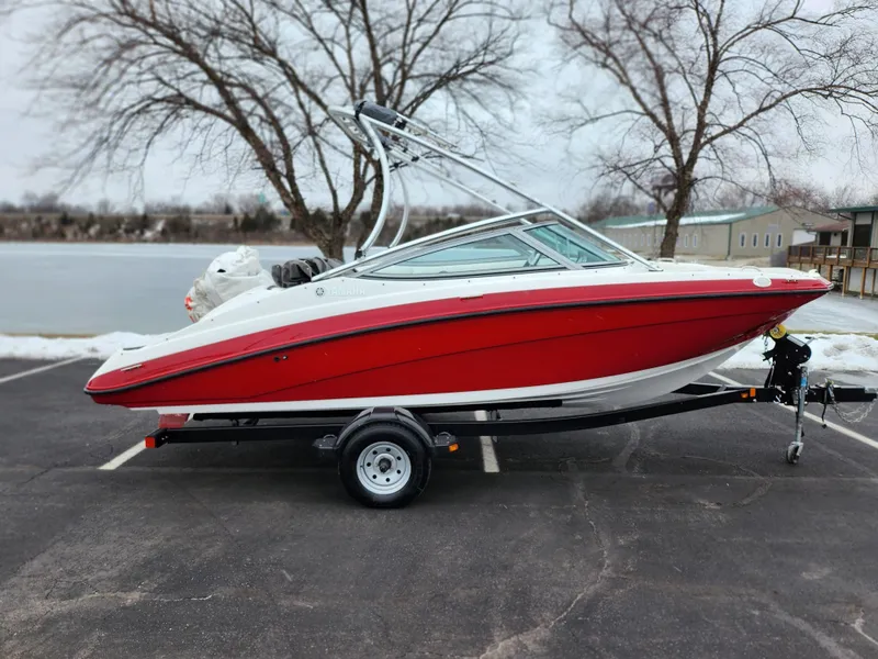 Slide: The Image of 2014 Yamaha Boats AR190, red and white, parked near a lake in winter. - 9