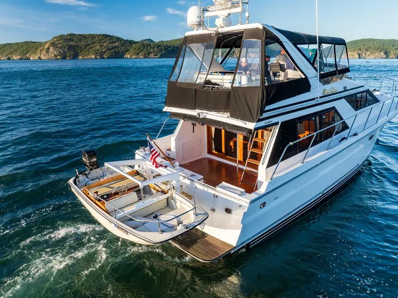 Slide: The Image of 1990 Ocean Alexander 48 Cockpit Motoryacht cruising on open water, scenic coastal backdrop. - 16