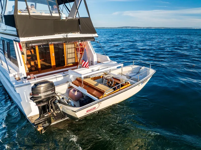 Slide: The Image of 1990 Ocean Alexander 48 Cockpit Motoryacht on open water with attached dinghy. - 17