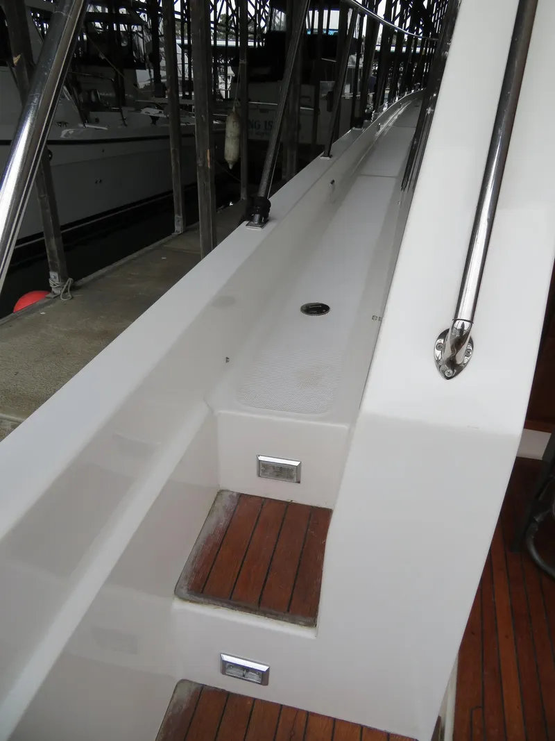 Slide: The Image of 1990 Ocean Alexander 48 Cockpit Motoryacht, featuring sleek white deck and wooden steps. - 28