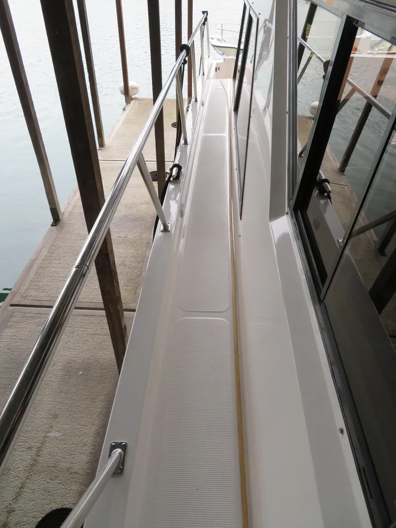 Slide: The Image of 1990 Ocean Alexander 48 Cockpit Motoryacht side deck view in marina. - 29