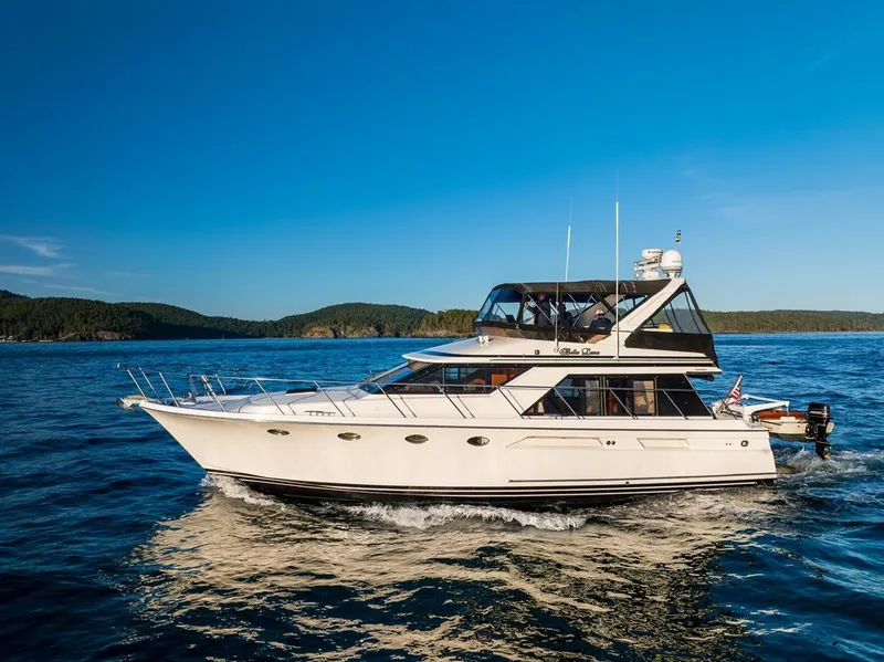 Slide: The Image of 1990 Ocean Alexander 48 Cockpit Motoryacht cruising on open water under clear blue skies. - 3