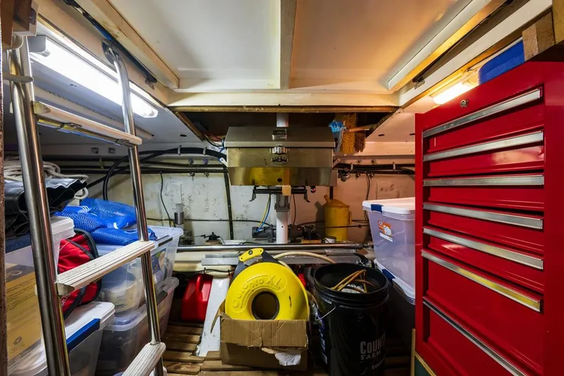 Slide: The Image of Engine room of 1990 Ocean Alexander 48 Cockpit Motoryacht with tools and storage. - 46